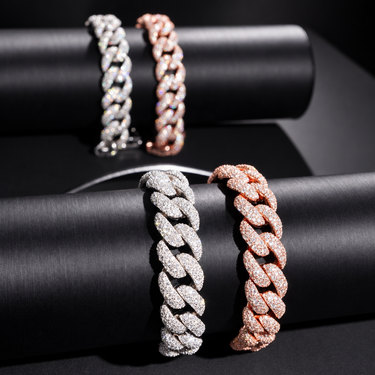 Mosaic 14mm moissanite Cuban link bracelets in Silver and Rose Gold displayed on black jewelry stands