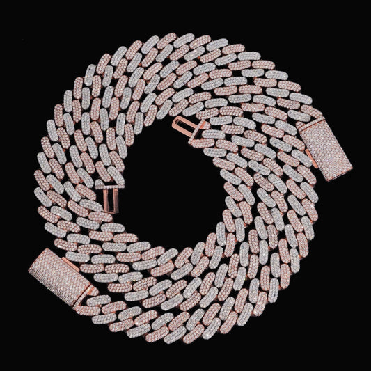 Two-tone 16mm moissanite Cuban link bracelet coiled on a black background